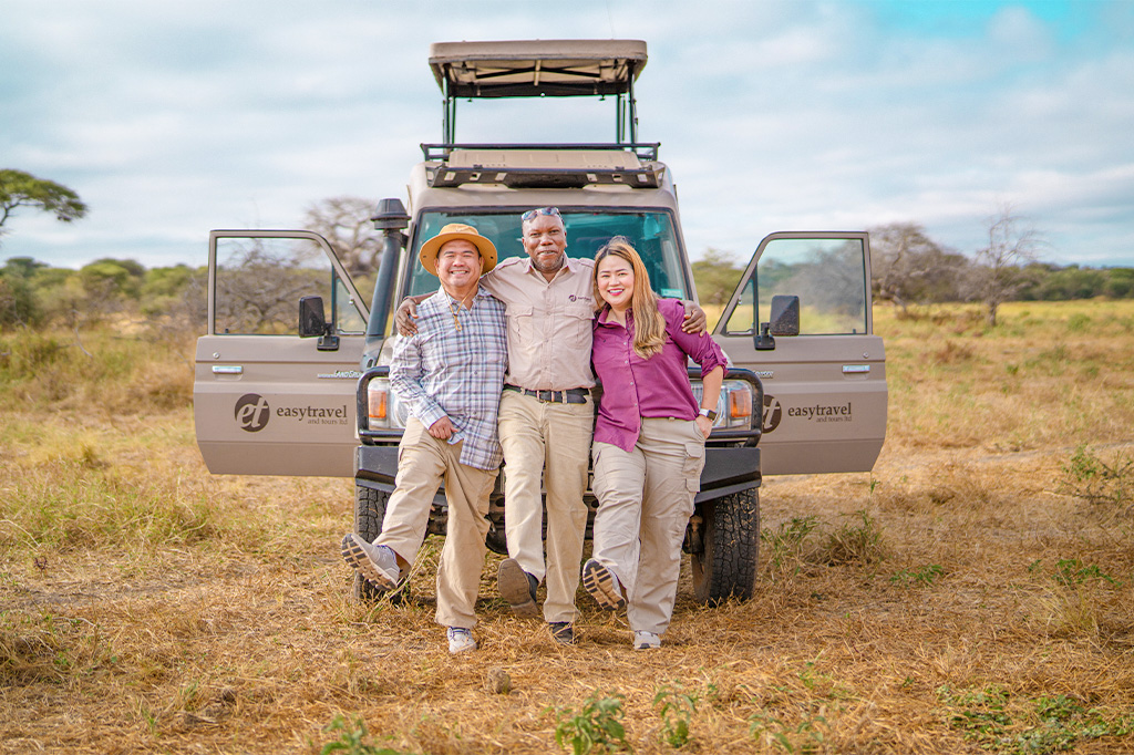 Happy tourist couple with Easy Travel driver guide in Tanzania