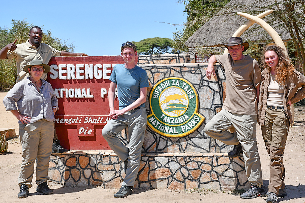 Tourists with their Easy Travel guide posing in front of the Serengeti sign