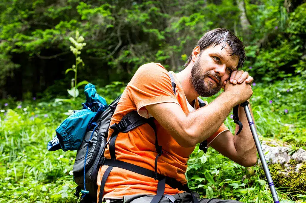 Young hiker with backpack resting on a rocky hill.jpg