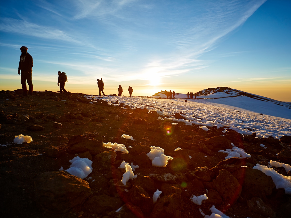 Silhouette of climbers climbing Mount Kilimanjaro during a golden hour morning