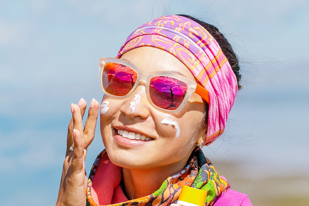 Tourist woman applying sunscreen