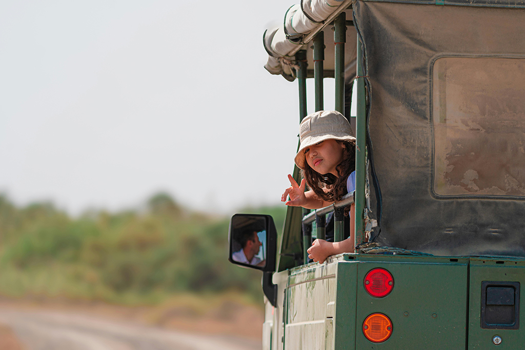 Young girl wearing hat while on safari in Tanzania