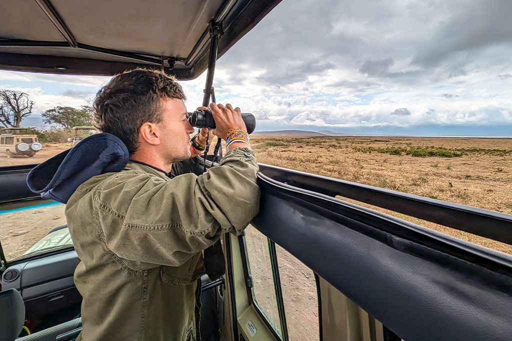 一名游客乘坐游猎车在米库米国家公园观赏野生动物