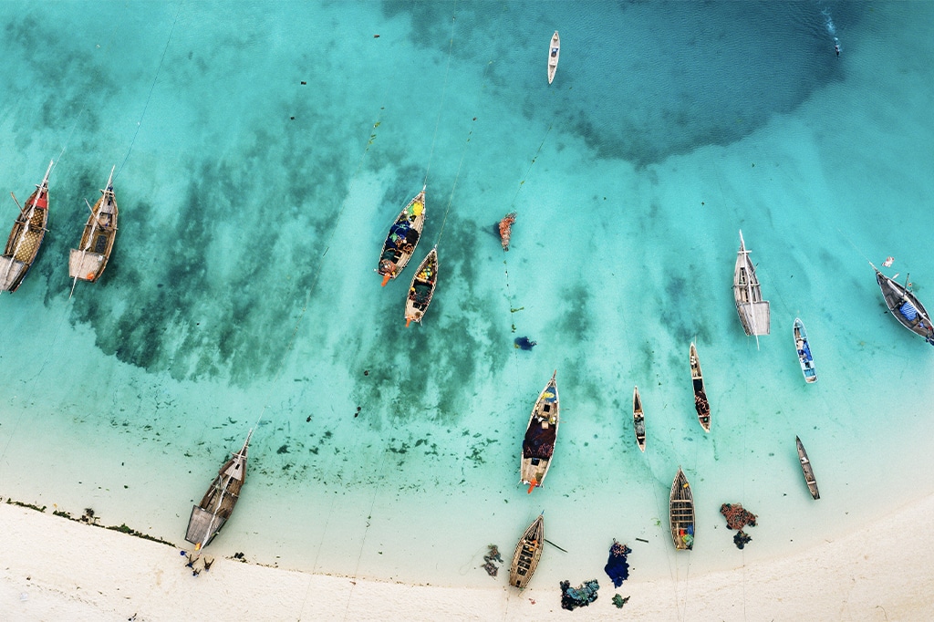 Вид с воздуха на лодки дау на пляже Кизимкази Димбани, Занзибар, Танзания