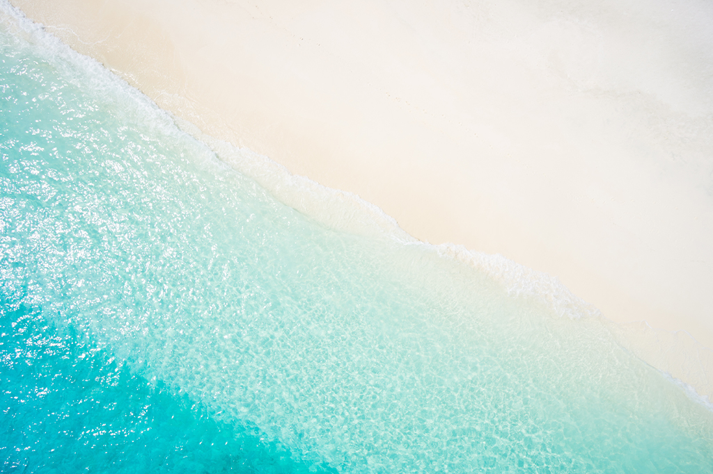 Aerial view of the white sandy beach shore of Mnemba Island, Tanzania