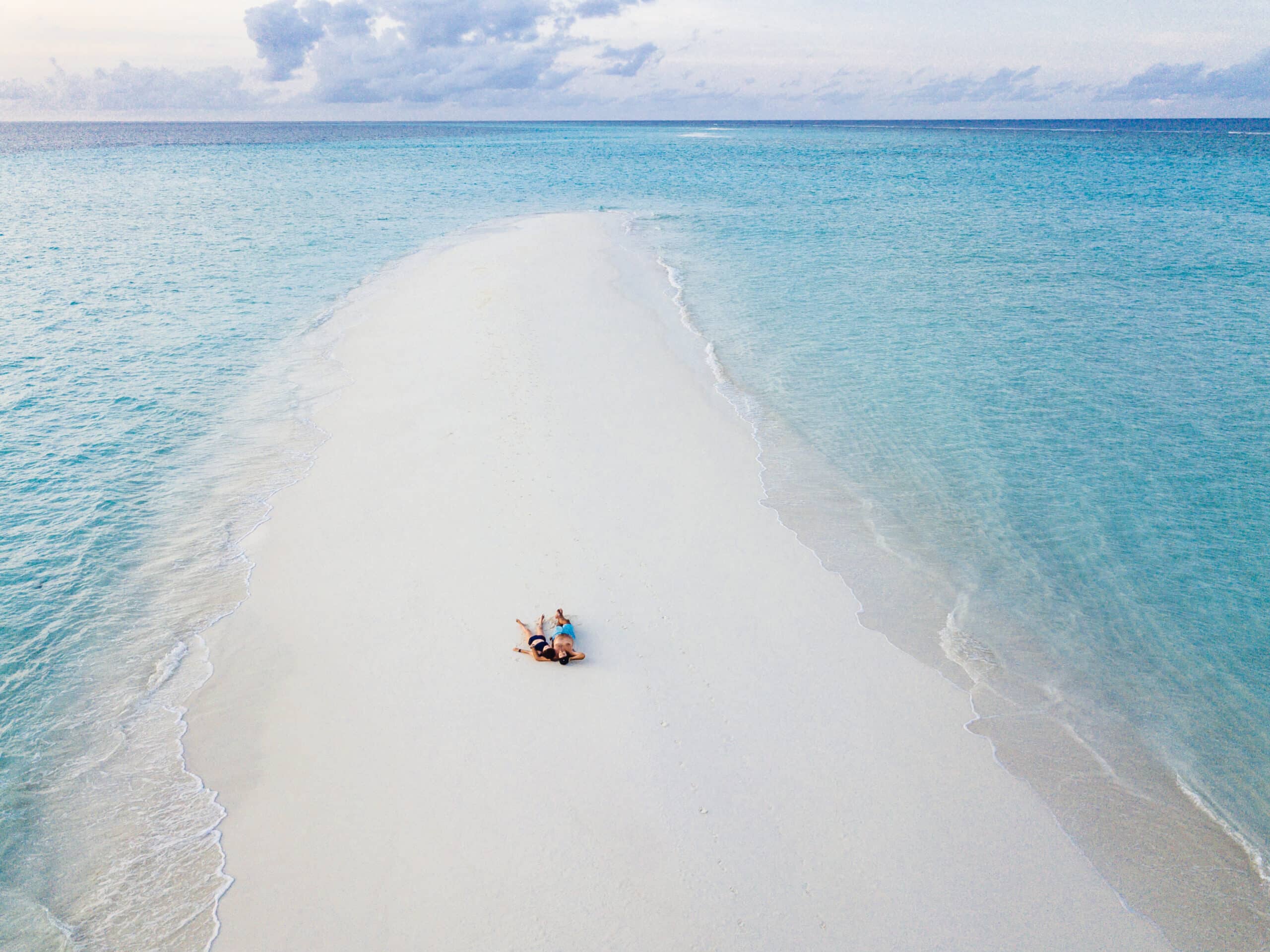 Couple lying on the sandbank at Uroa Beach Zanzibar