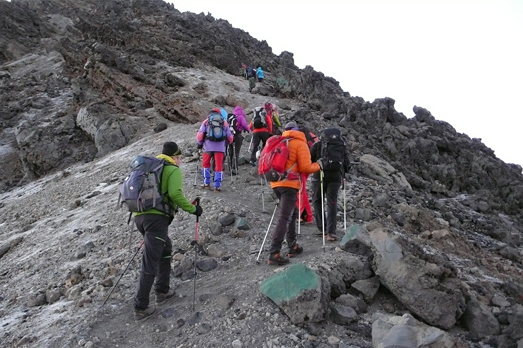 Group of hikers hiking through the rocky trails of mount meru