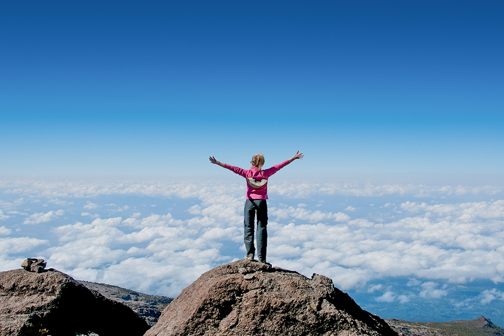 Glücklicher junger Trekker über den Wolken auf der Machame Route Kilimandscharo Glücklicher junger Trekker über den Wolken auf der Machame-Route, Kilimandscharo