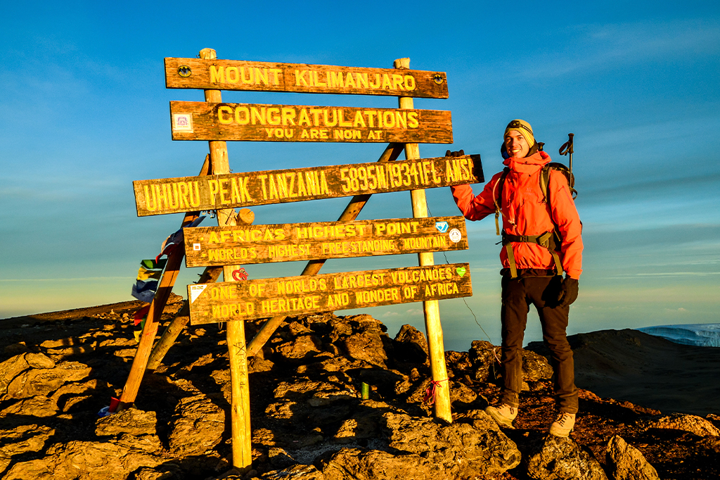 Турист на пике Ухуру на горе Килиманджаро в Танзании