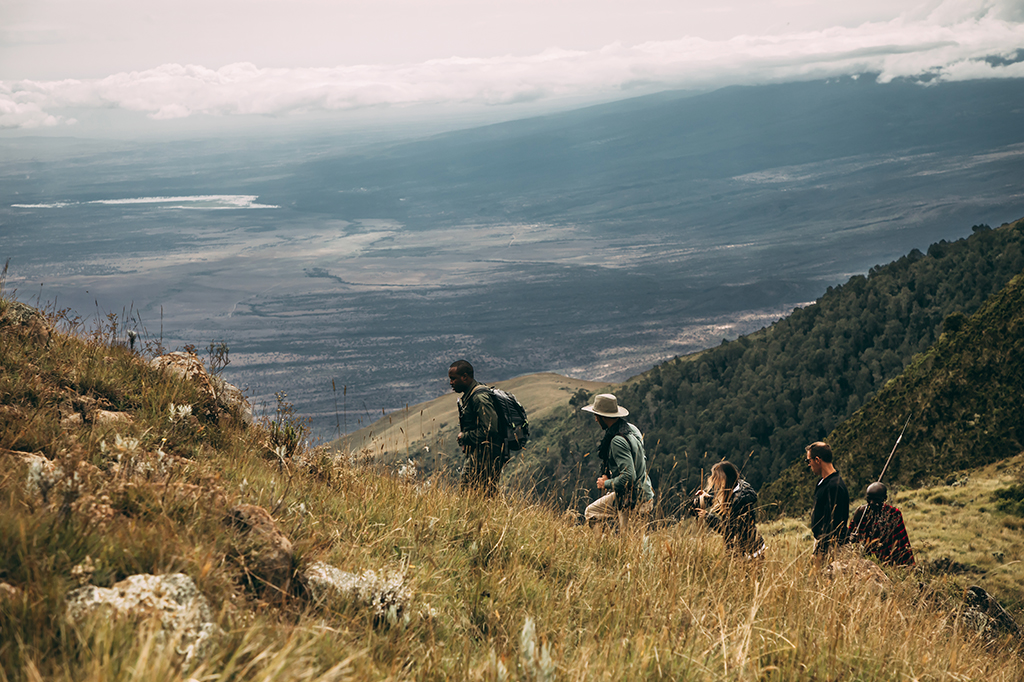 タンザニアのンゴロンゴロでマカロット山をハイキングする観光客