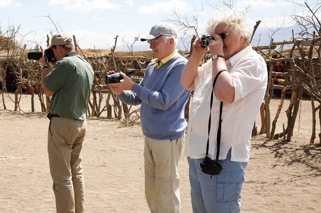 Tourists taking photos in a maasai village at serengeti national park, tanzania