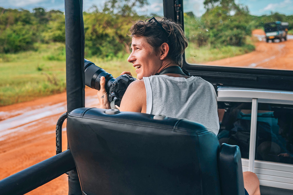 Tourist photographer on a safari vehicle in arusha national park, tanzania