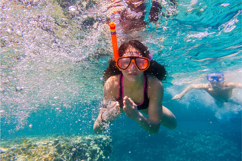 Hermana y hermano haciendo snorkel en la isla Bawe