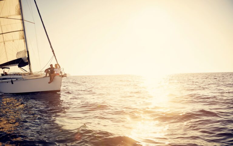 Junge Paare sind auf einer Yacht und genießen den wunderschönen goldenen Sonnenuntergang am Jambiani Beach, Sansibar