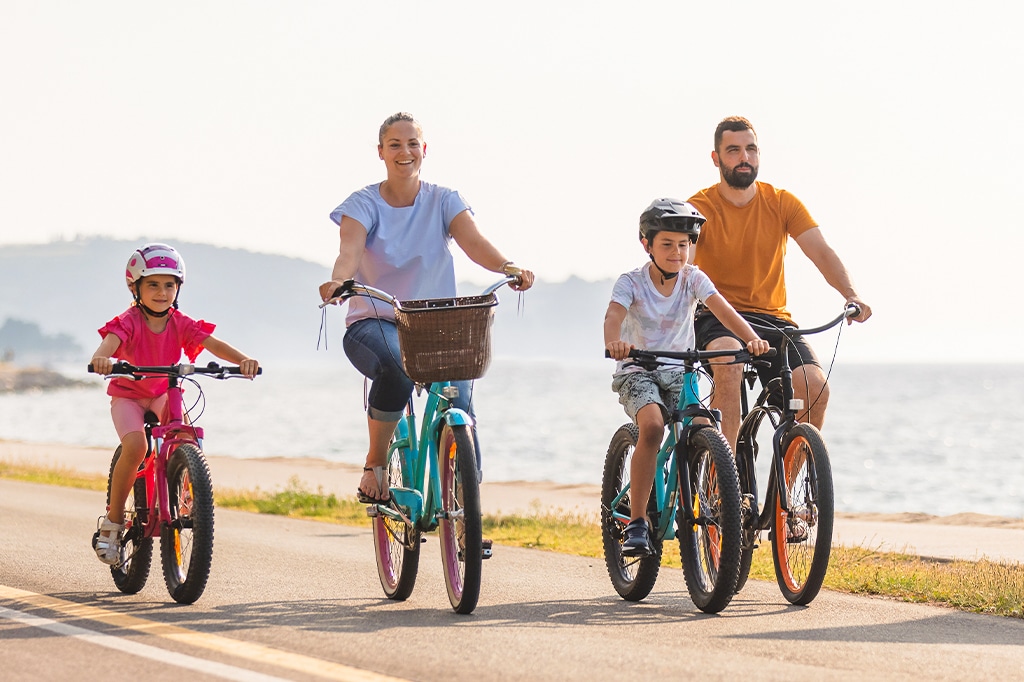 Touristenfamilie auf einer Fahrradtour entlang der Küste von Sansibar, Tansania