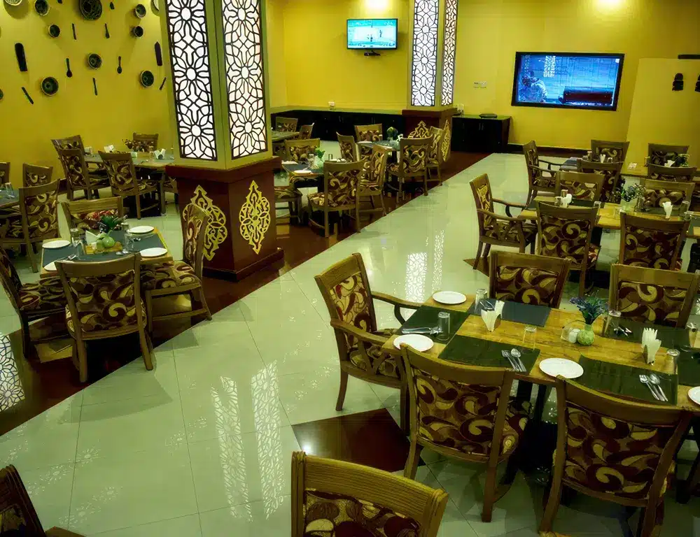 Een elegante hotelrestaurantruimte met een rijk gedecoreerde inrichting, gedekte tafels en sfeervolle verlichting, ideaal voor een luxueuze dinerervaring in...
