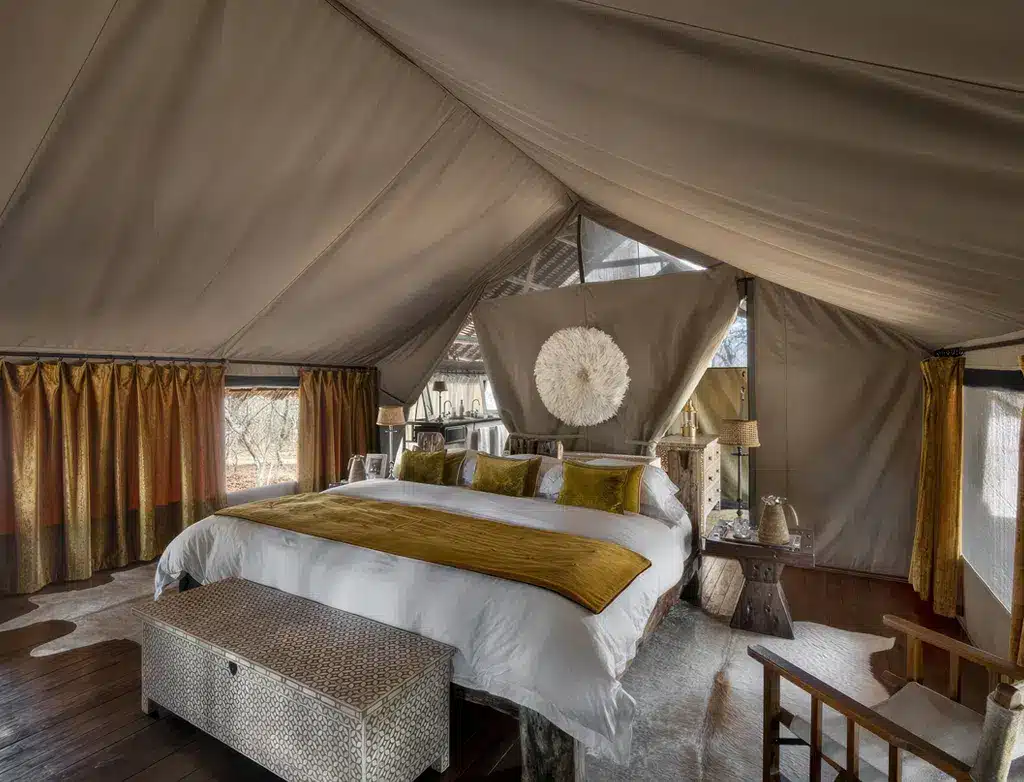 Lyxigt safaritält på Jongomero Camp, Tanzania, med en plyschsäng, elegant inredning och naturligt ljus.