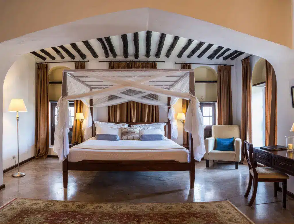 Luxe slaapkamer in Kisiwa House, Tanzania, met een hemelbed, elegante inrichting en sfeervolle verlichting.