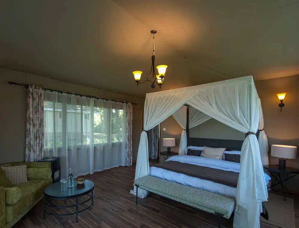 恩戈罗恩戈罗狮爪旅馆的豪华客房，配有四柱床、优雅的灯光和大窗户。.