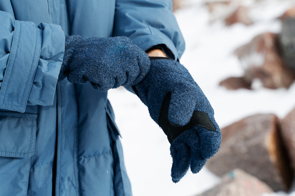 A close up of a hiker putting on gloves A close up of a hiker putting on gloves