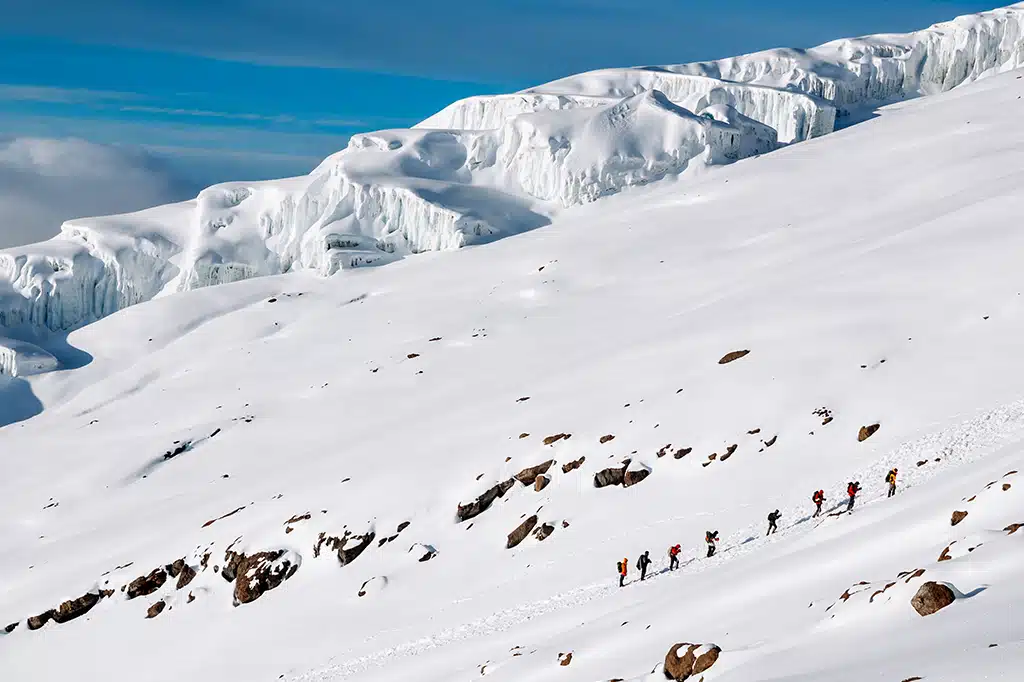 Een groep wandelaars trekt door de gletsjerpaden van de Kilimanjaro.jpg
