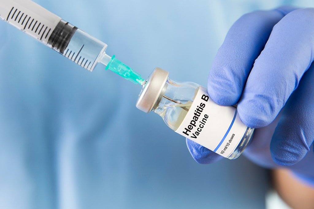 医師が注射器にB型肝炎ワクチンを注入している