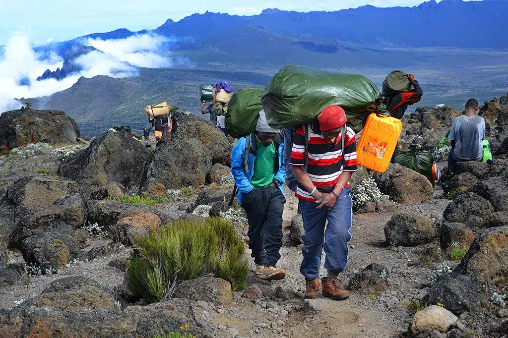 Kilimanjaro-dragers dragen voorraden over de paden van Mount Kilimanjaro.jpg