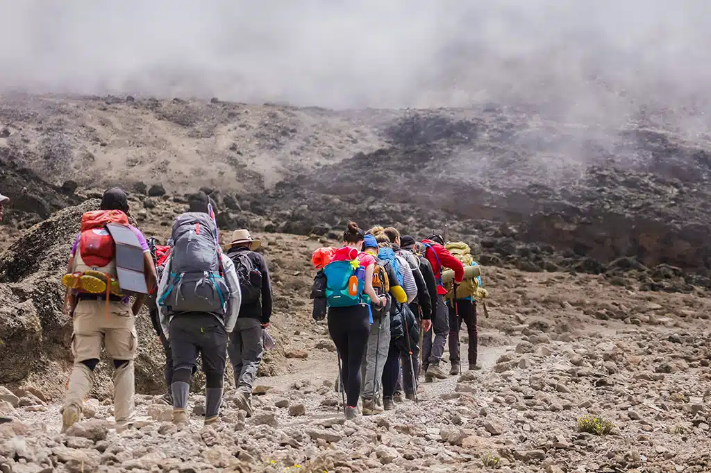 Toeristenwandelaars trekken door het mistige pad van de Kilimanjaro.jpg