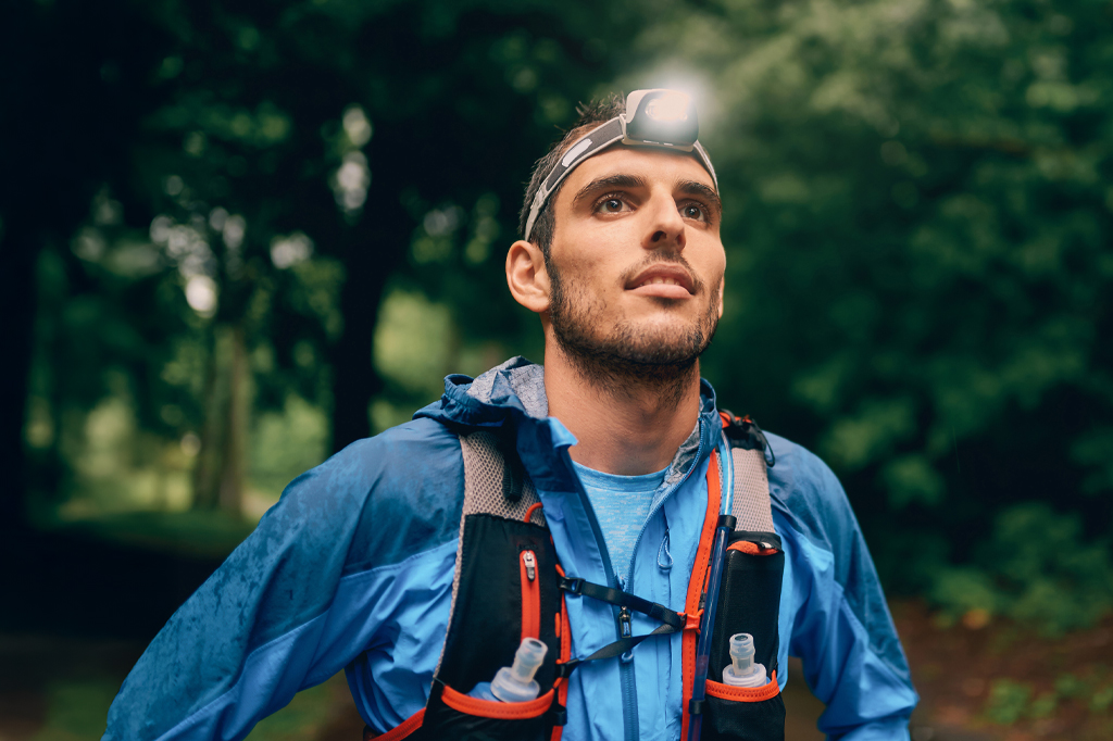 Young man with a head mounted flashlight hiking through the trails of Mount Kilimanjaro 1 Young man with a head mounted flashlight hiking through the trails of Mount Kilimanjaro 1