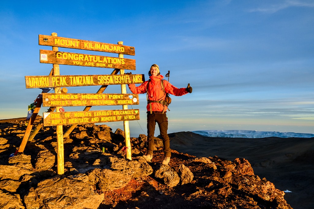 A young Kilimanjaro hiker at the Uhuru peak of Mount Kilimanjaro, Tanzania