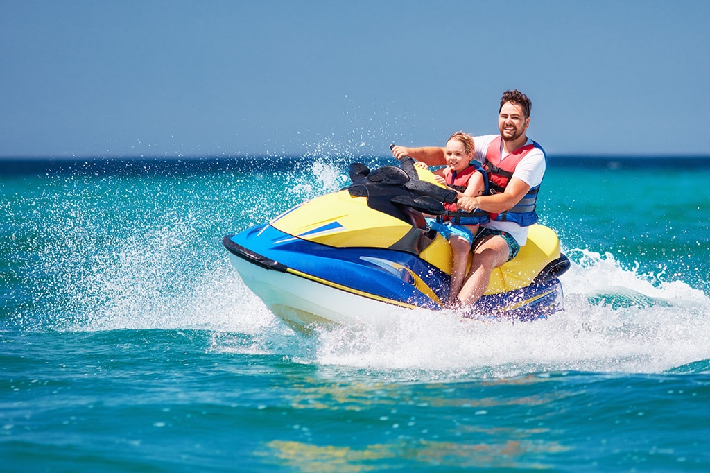 坦桑尼亚桑给巴尔，一对父子正在玩水上摩托艇