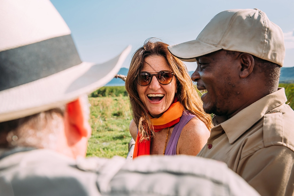 Blije toeristen en Easy Travel safarigids lachen samen Blije toeristen en Easy Travel safarigids lachen samen