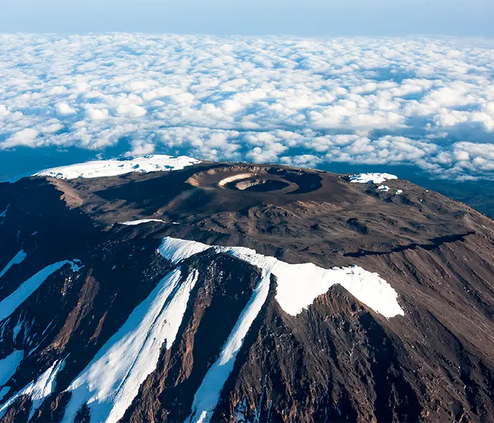 乞力马扎罗山的基博火山口在云海上方急剧升起。.