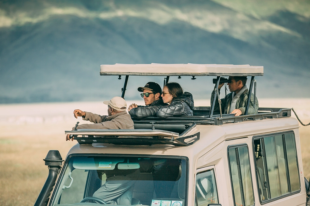 Tourists and Easy Travel safari guide viewing the landscape from the roof of a safari vehicle